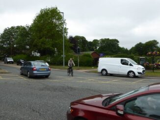 A cyclist is waiting to turn right in the middle of a junction